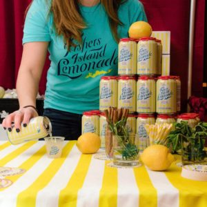 Photo of brand ambassador pouring a canned cocktail into a glass at an event to promote jobs & career opportunities to prospective employees