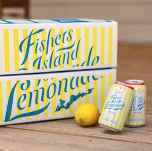 Cases of Fishers Island Lemonade on porch with lemon and canned cocktails. Store carrying Fishers Island Lemonade